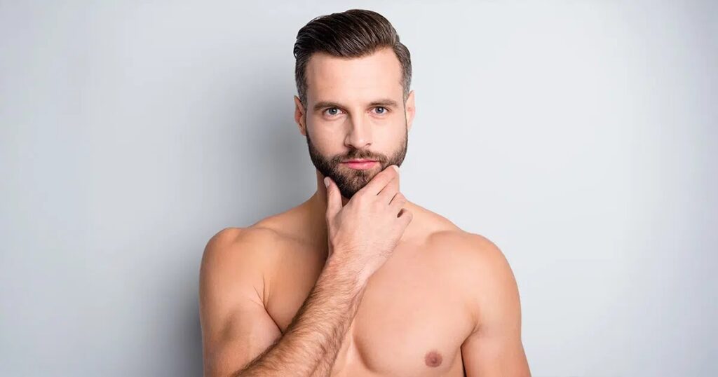 Shirtless man with styled hair and beard touching his chin, representing chin liposuction options for men.
