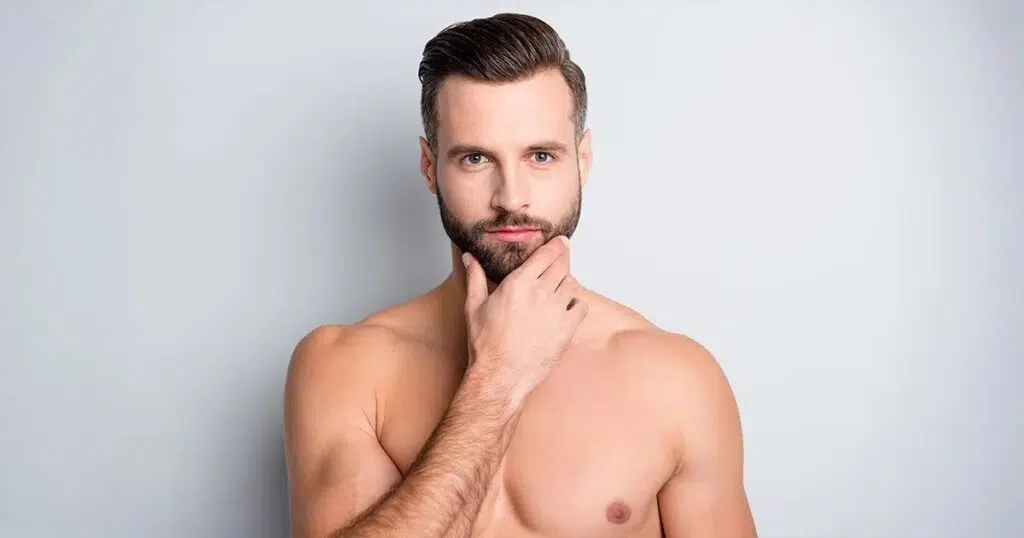 Shirtless man with styled hair and beard touching his chin, representing chin liposuction options for men.