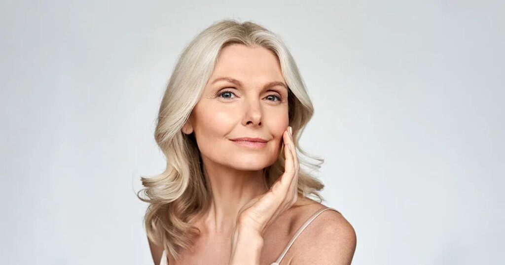 Older woman touching her face