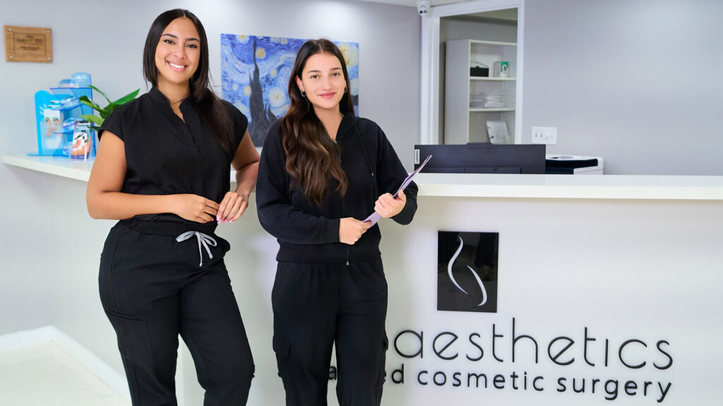 Two Mia Aesthetics staff members standing at the clinic reception desk