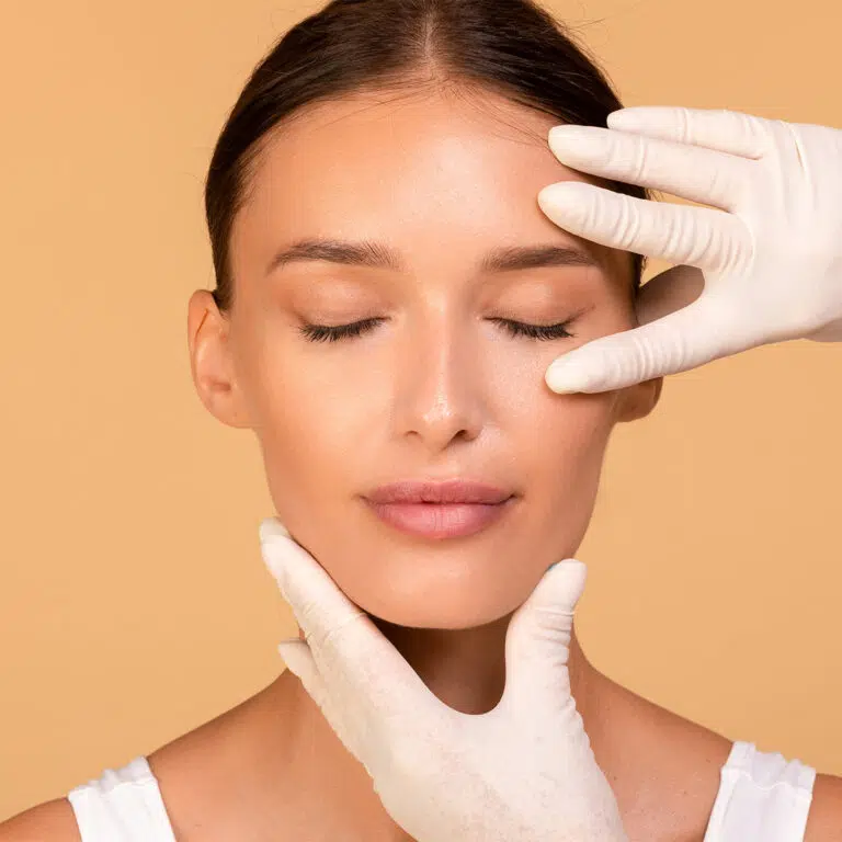 Woman with eyes closed as gloved hands examine her eyelid area during an assessment