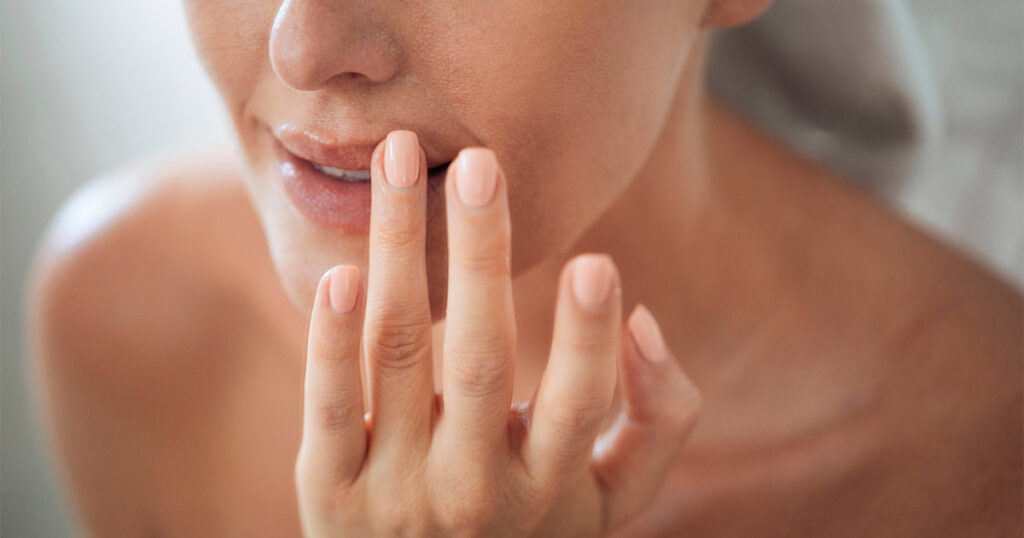 Woman touching her lip after lip lift surgery.