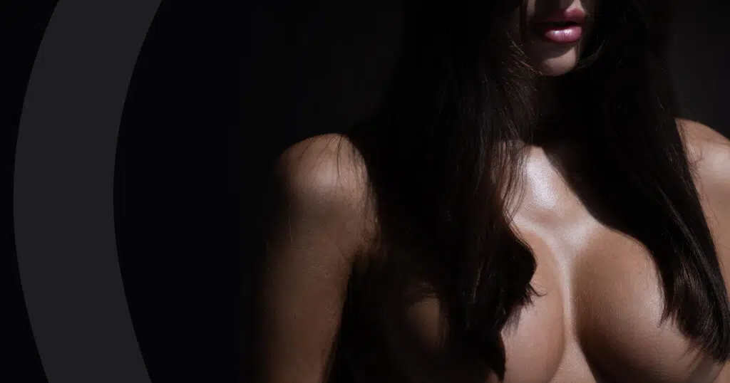 Woman with long dark hair falling over her chest, illustrating high-riding breast implants